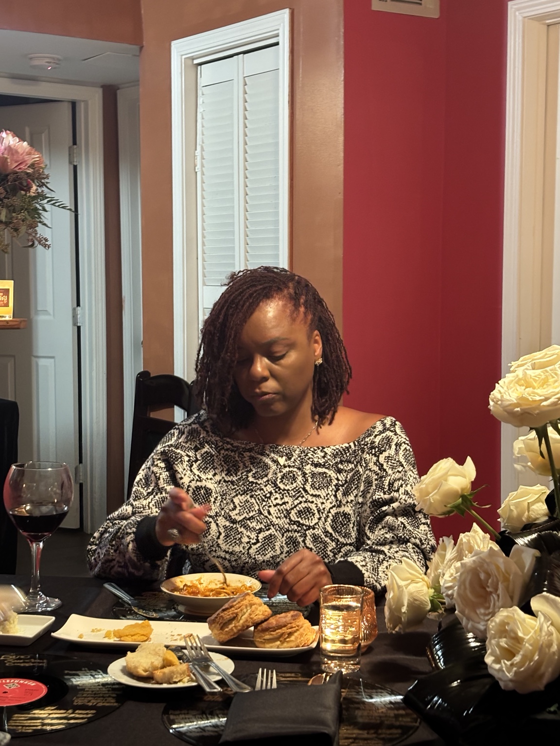 A guest enjoying dinner beside white roses