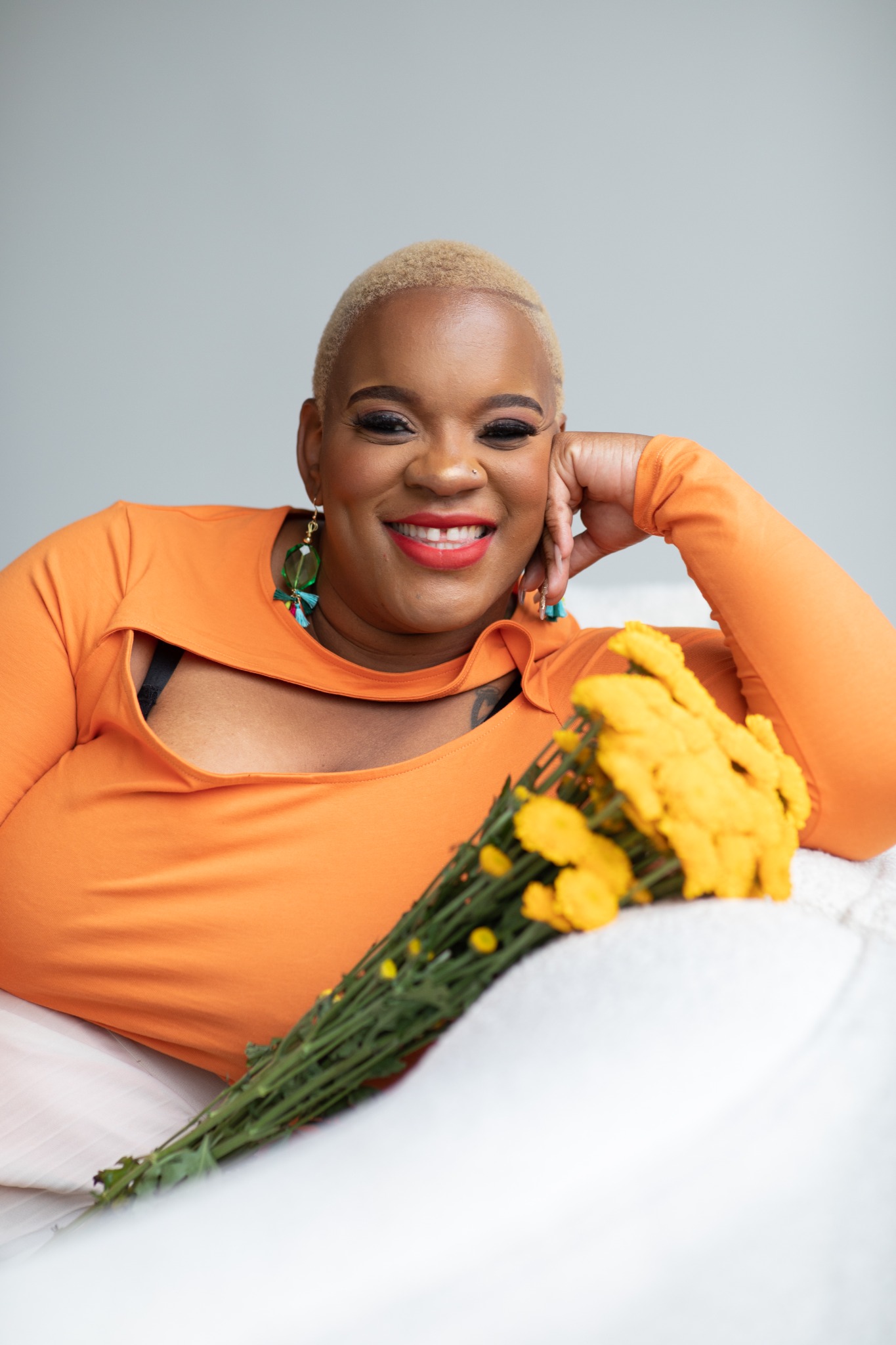 Ronisha Arlene smiling with a bouquet of yellow flowers