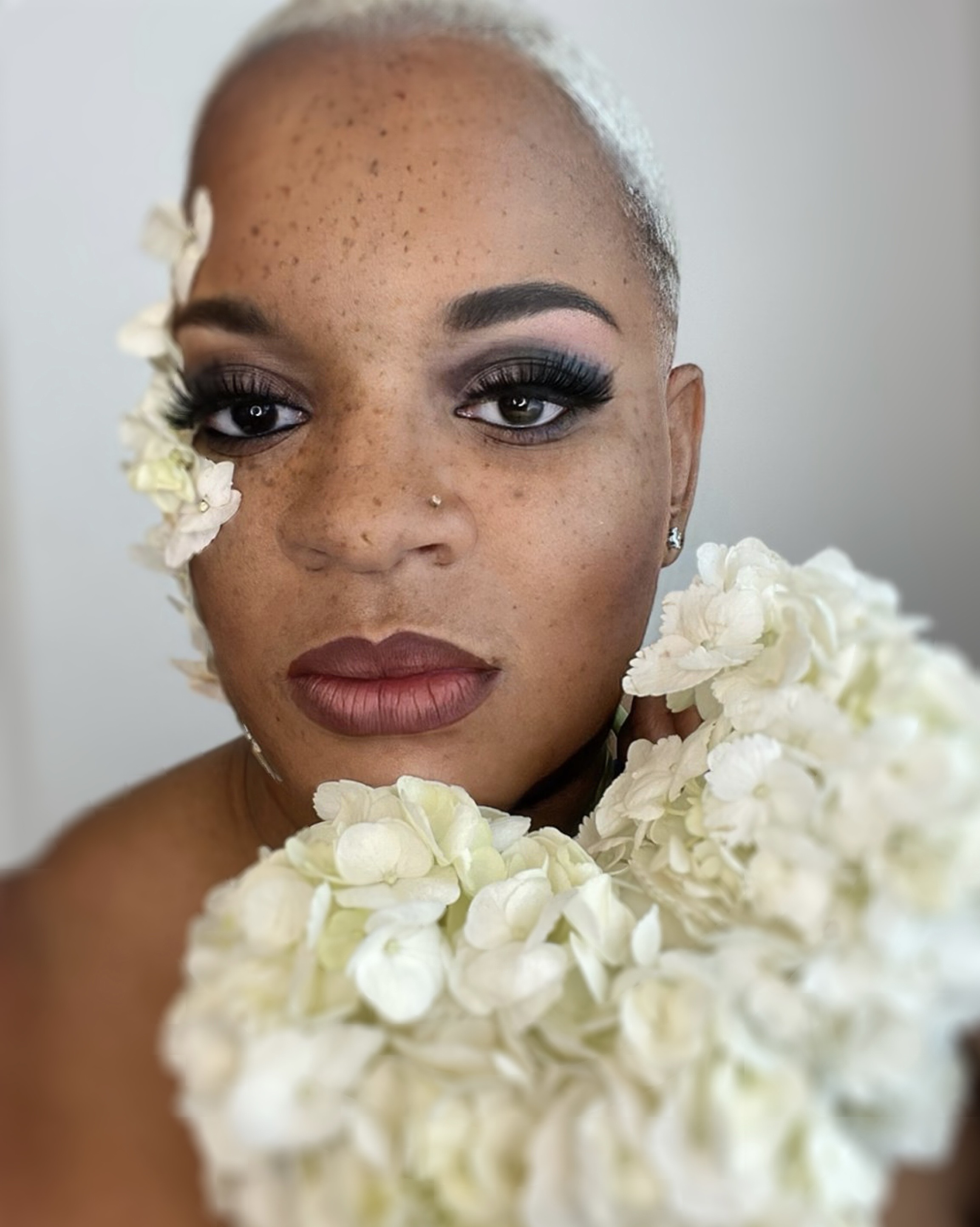 A close portrait of Ronisha framed by white flowers