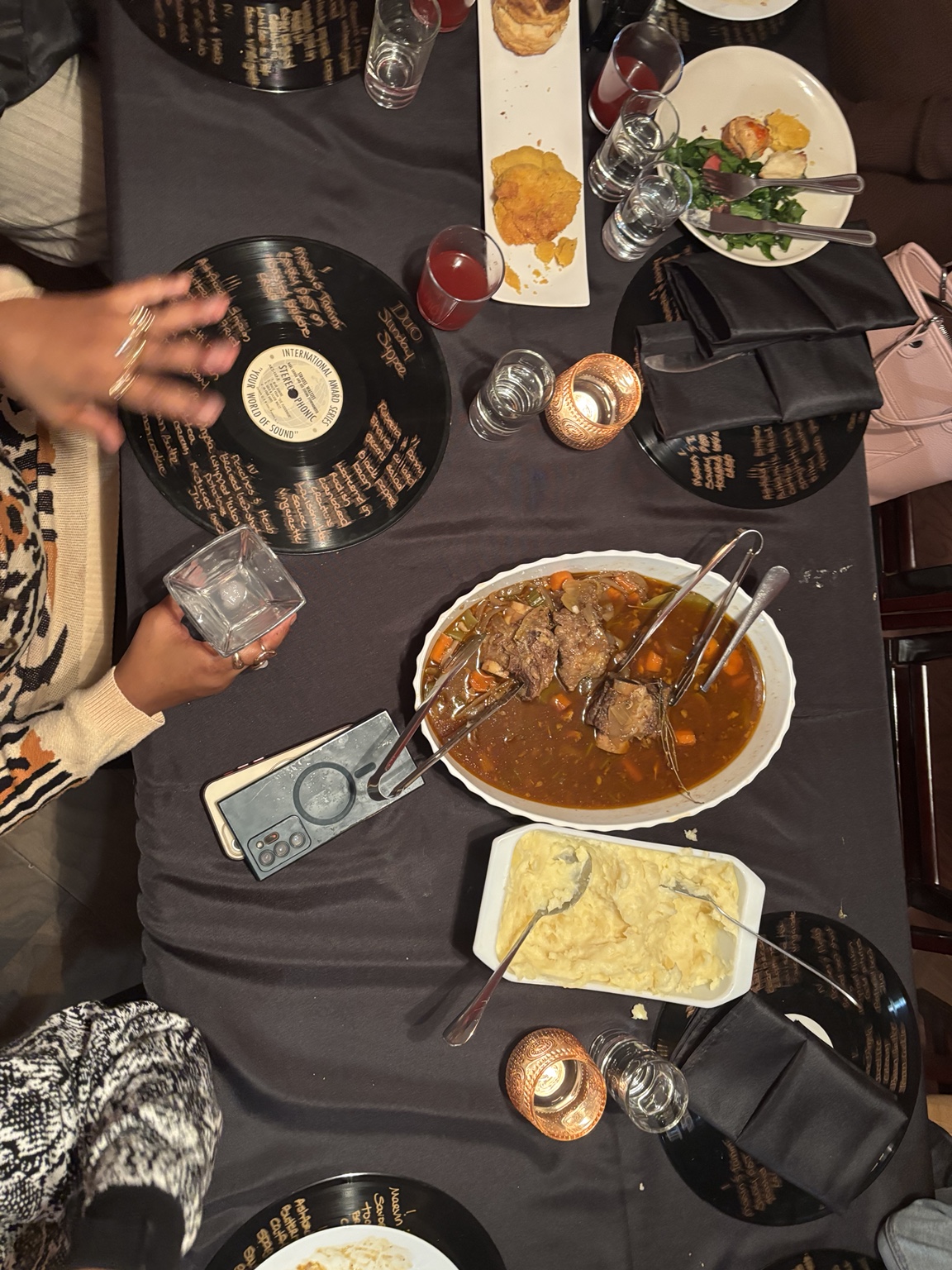 An overhead view of Sunday Supper, with shared dishes and handwritten vinyl record menus