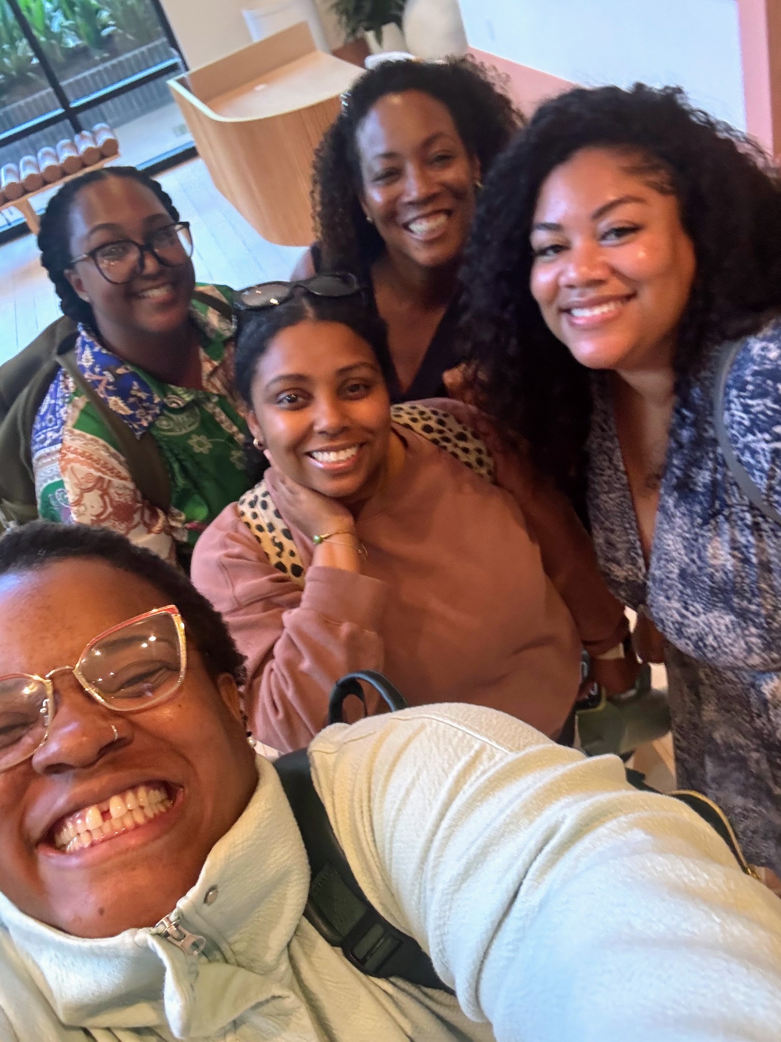 Five women smiling together for a group selfie